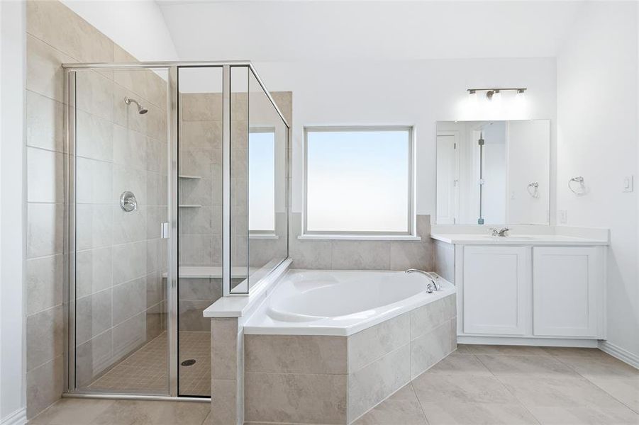 Bathroom featuring a corner soaking tub, a separate glass-enclosed shower with tiled walls and a built-in bench, a single vanity with white cabinetry, and a rectangular window