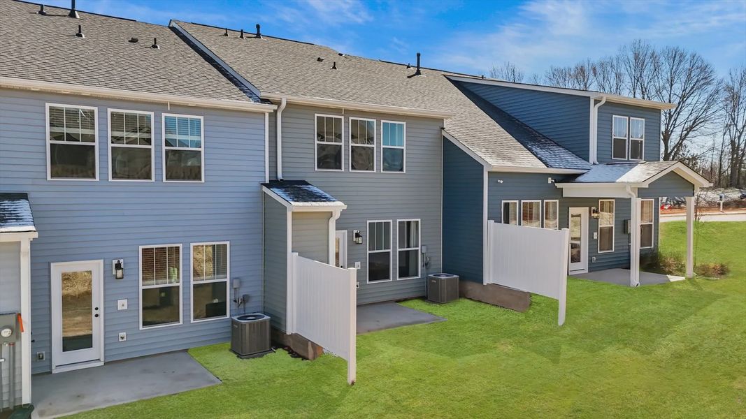 Townhome exterior with craftsman design, large windows, garage, two car parking pad, and blue siding at Aspen Ridge in Lyman