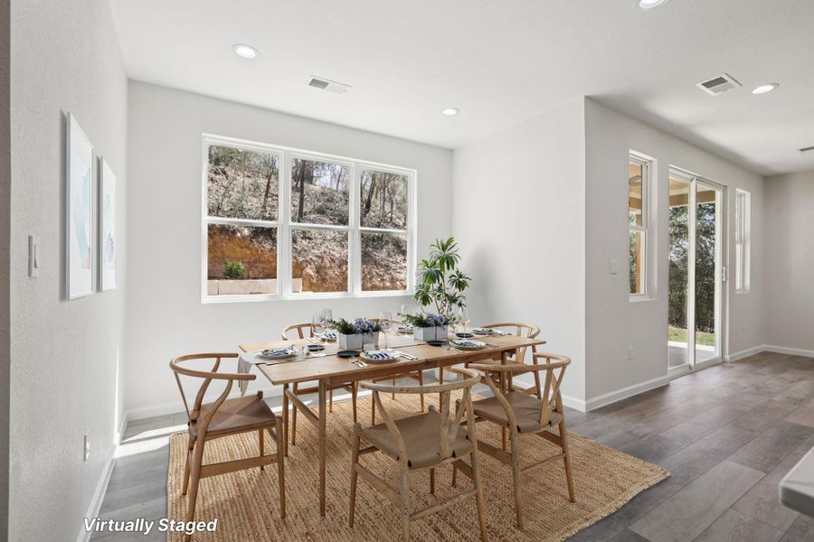 Virtually Staged Dining area with  light wood-type laminate flooring and recessed lighting
