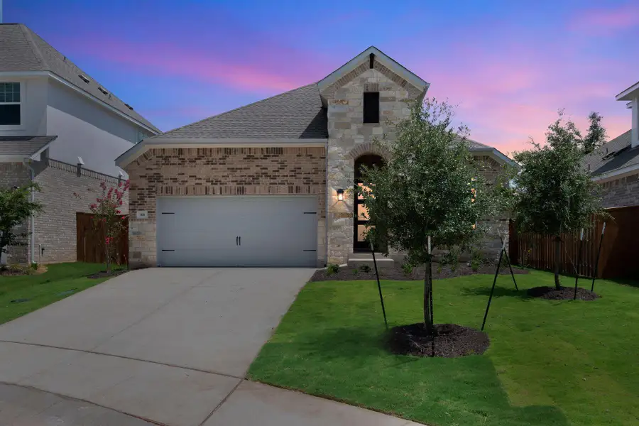 French provincial home featuring stone siding, a shingled roof, driveway, and an attached garage