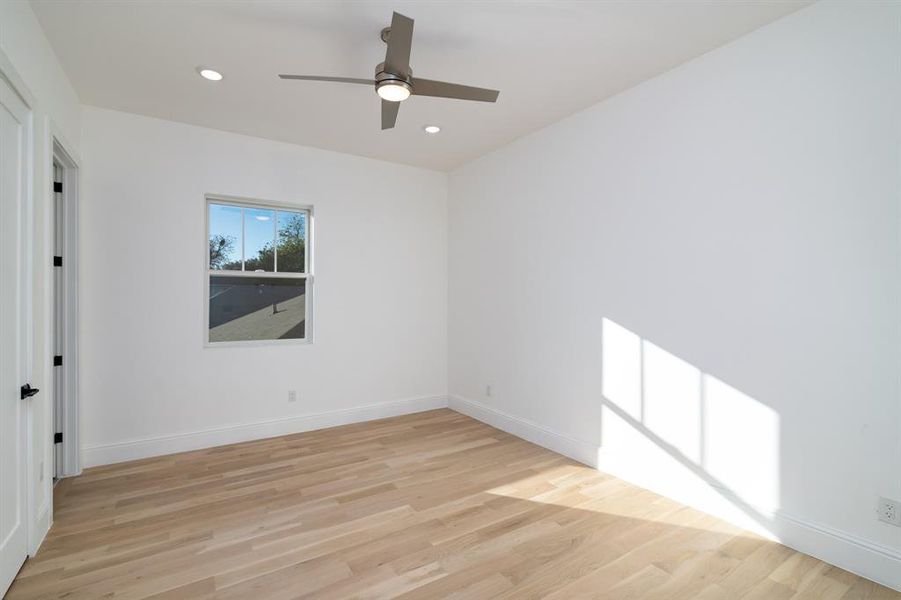 Empty room with light hardwood / wood-style flooring and ceiling fan