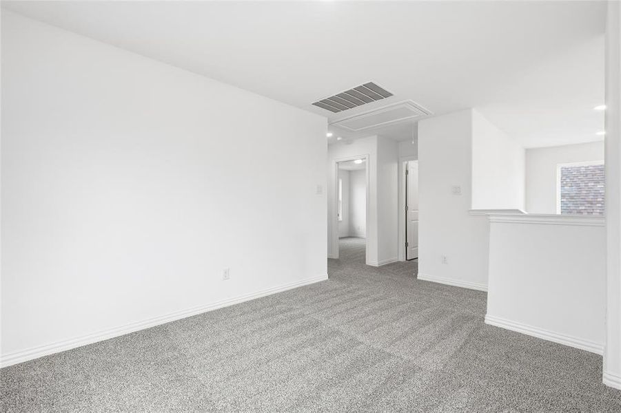 Carpeted empty room featuring attic access and recessed lighting