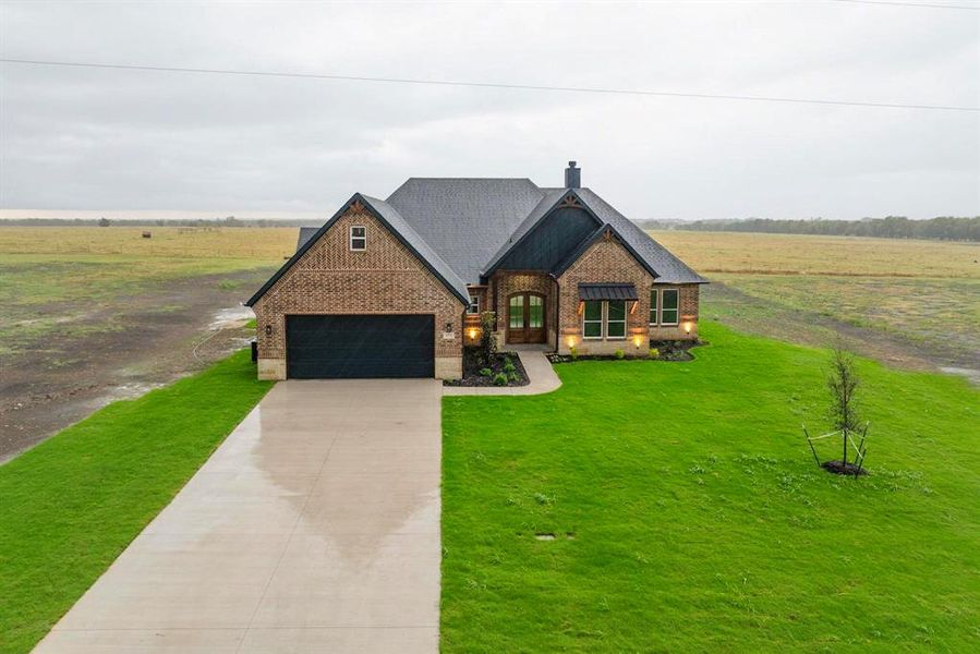 View of front of property featuring a garage and a front yard