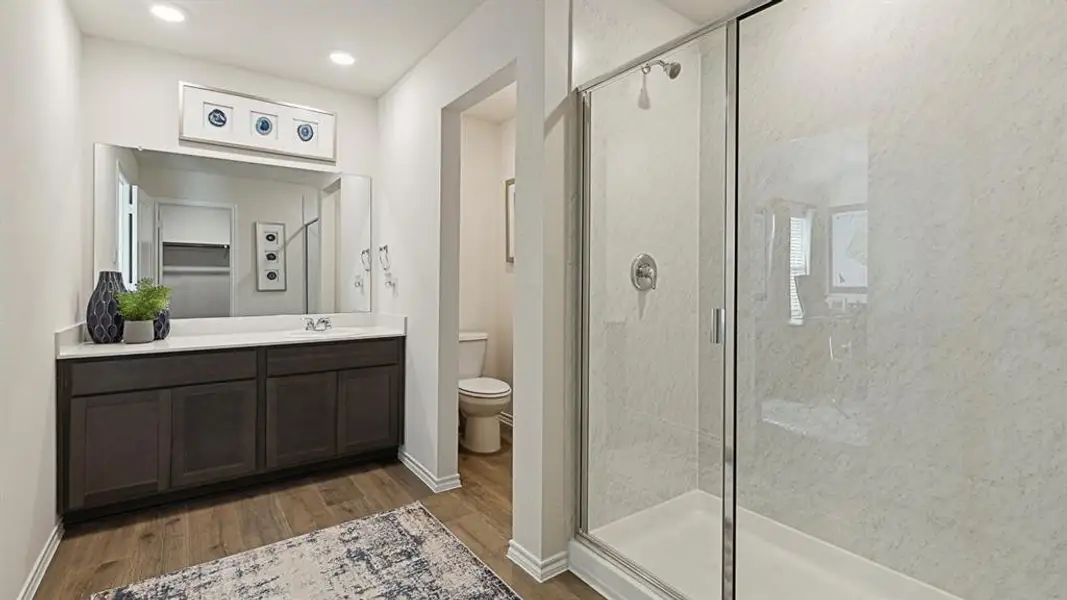 Bathroom featuring a marble finish shower, vanity, and light wood-style floors Bathroom featuring a marble finish shower, vanity, and light wood-style floors