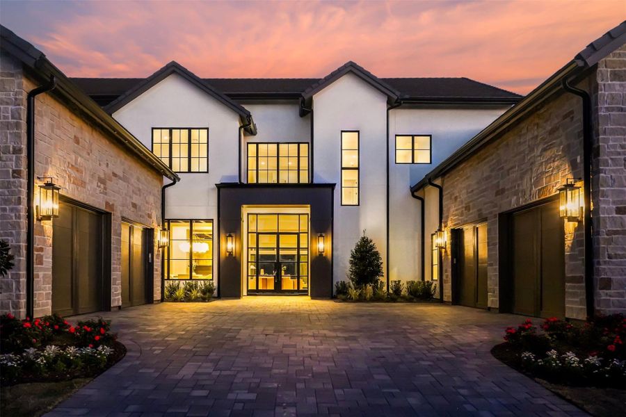 Welcome to 50 Aria Isle, a modern, timeless beauty with a cinimatic first impression. The exterior features a combination of light-colored stucco and stone, accented by large windows. A spacious 8 car driveway leads to a well-lit front door and a 4-car garage, creating a welcoming and luxurious curb appeal. Welcome to 50 Aria Isle, a modern, timeless beauty with a cinimatic first impression. The exterior features a combination of light-colored stucco and stone, accented by large windows. A spacious 8 car driveway leads to a well-lit front door and a 4-car garage, creating a welcoming and luxurious curb appeal.