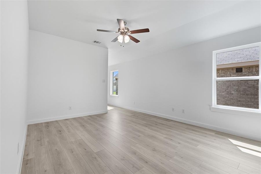 Spare room with light wood finished floors and a ceiling fan Spare room with light wood finished floors and a ceiling fan