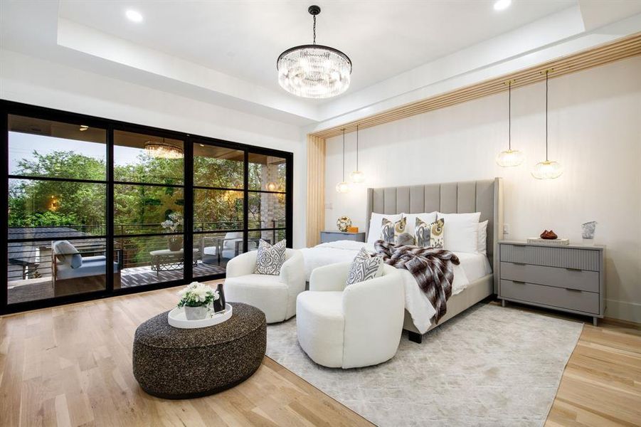 Expansive floor-to-ceiling sliding glass doors with black framing, wood-finish flooring, a contemporary chandelier, recessed ceiling lighting, and a light wood slat accent wall Expansive floor-to-ceiling sliding glass doors with black framing, wood-finish flooring, a contemporary chandelier, recessed ceiling lighting, and a light wood slat accent wall