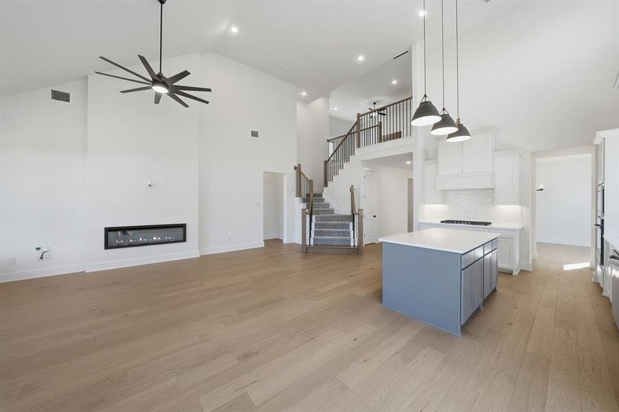 Kitchen featuring blue cabinetry, open floor plan, hanging light fixtures, a center island, and white cabinets Kitchen featuring blue cabinetry, open floor plan, hanging light fixtures, a center island, and white cabinets