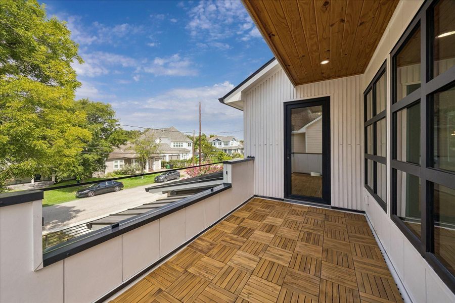 Charming balcony with elegant wood decking, offering a nice view of the neighborhood and lush greenery. Charming balcony with elegant wood decking, offering a nice view of the neighborhood and lush greenery.