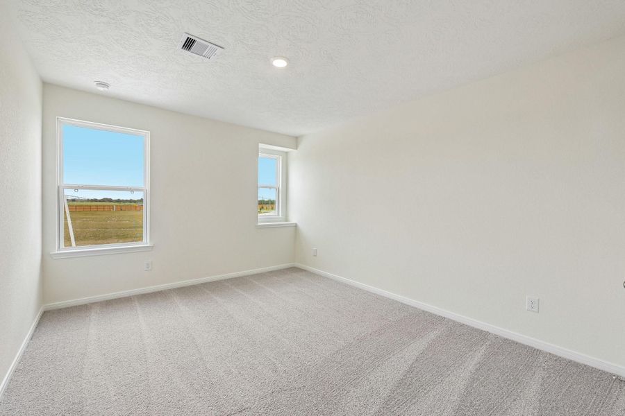 Well appointed secondary bedroom that features plush carpeting, neutral paint tones, recessed lighting, large window, and a generously sized closet.