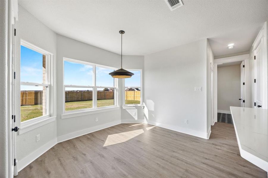 Unfurnished dining area with light wood-style flooring and baseboards