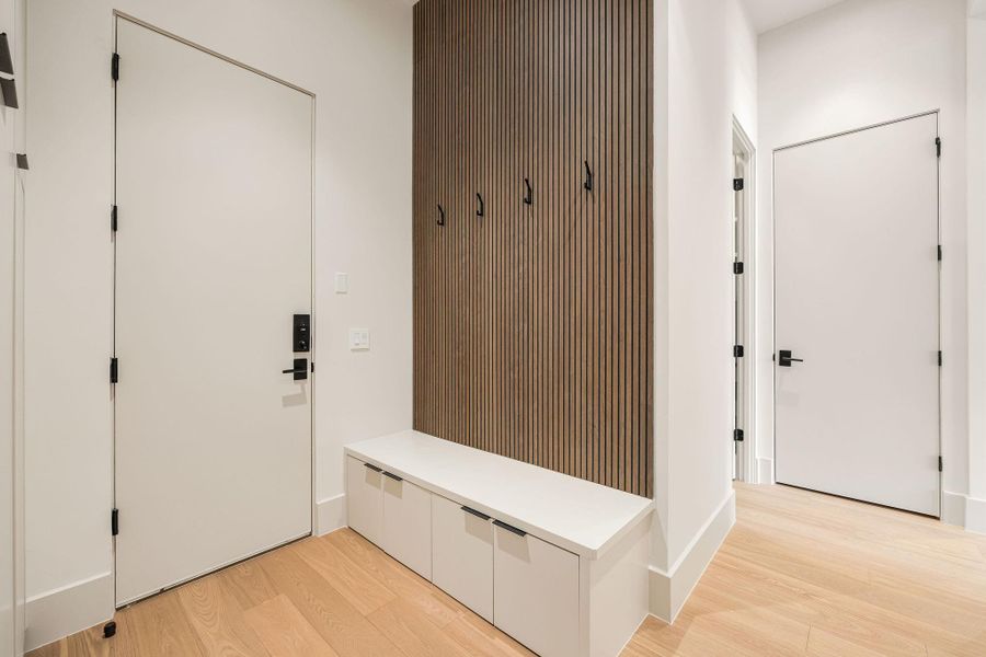 [MUDROOM] Designed for effortless functionality, the spacious mudroom features custom built-in storage, hanging hooks, generous cabinetry, and dedicated spaces for cleaning supplies and everyday essentials.