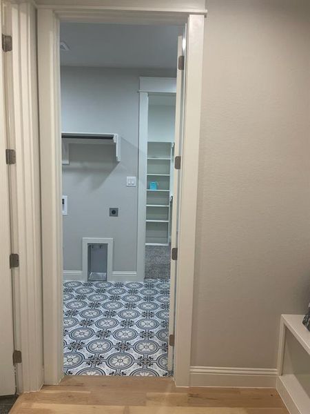 Laundry area with electric dryer hookup, baseboards, and wood finished floors Laundry area with electric dryer hookup, baseboards, and wood finished floors