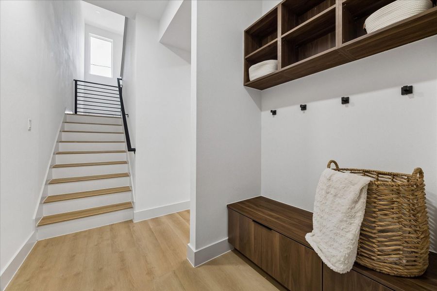 Custom built cabinetry, integrated bench seating, and open shelving create a designer mudroom that brings beauty and organization to everyday living.