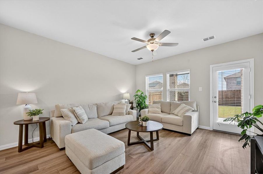 Living room with light wood-type flooring and ceiling fan