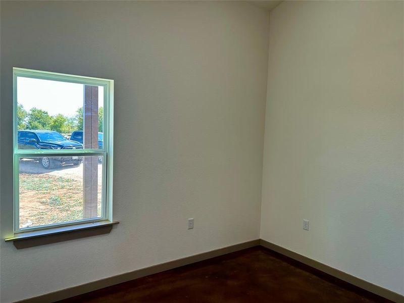 Spare room with baseboards and concrete floors
