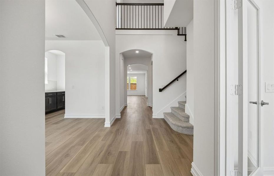 Welcoming entry into home with two story ceilings