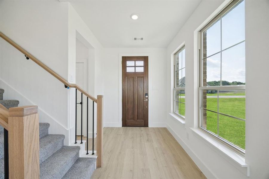 Foyer entrance with light wood-style flooring, stairs, and recessed lighting Foyer entrance with light wood-style flooring, stairs, and recessed lighting