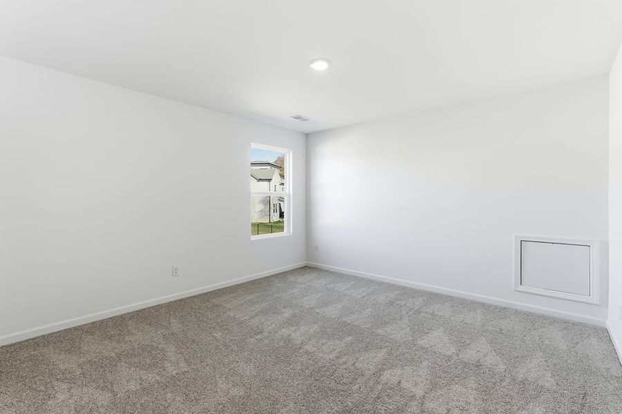 A room with a window and carpet.