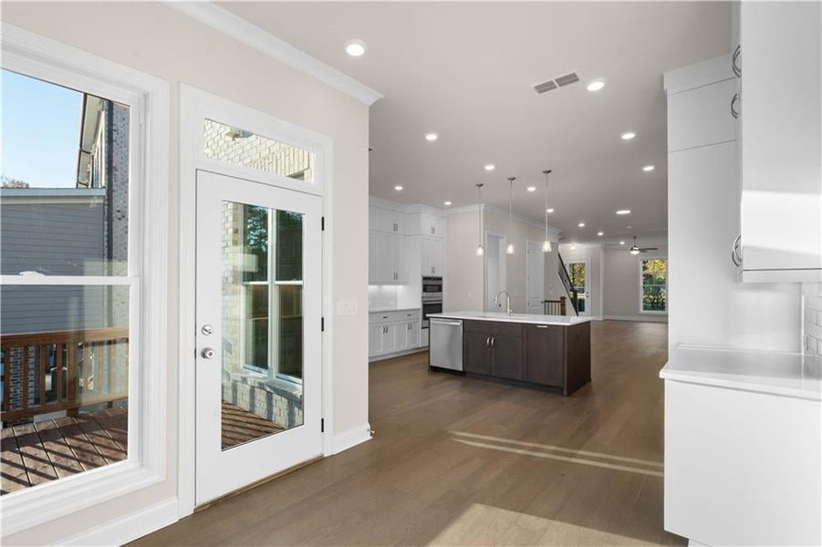Kitchen with white cabinetry, open floor plan, recessed lighting, an island with sink, and hanging light fixtures