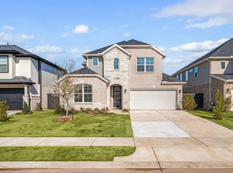 Front exterior of a new home in Harvest Green, Richmond, TX, highlighting curb appeal (Image 1). Front exterior of a new home in Harvest Green, Richmond, TX, highlighting curb appeal (Image 1).