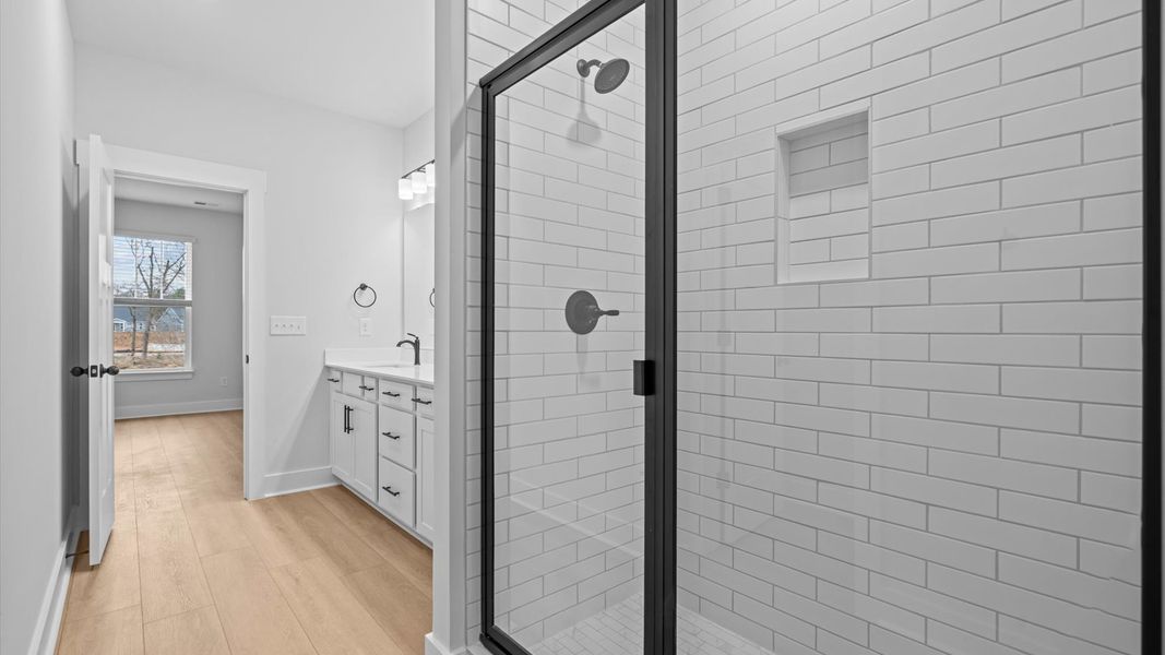 Highly functional and elegant en-suite with dual vanities, tiled walk-in shower, and refined finishes