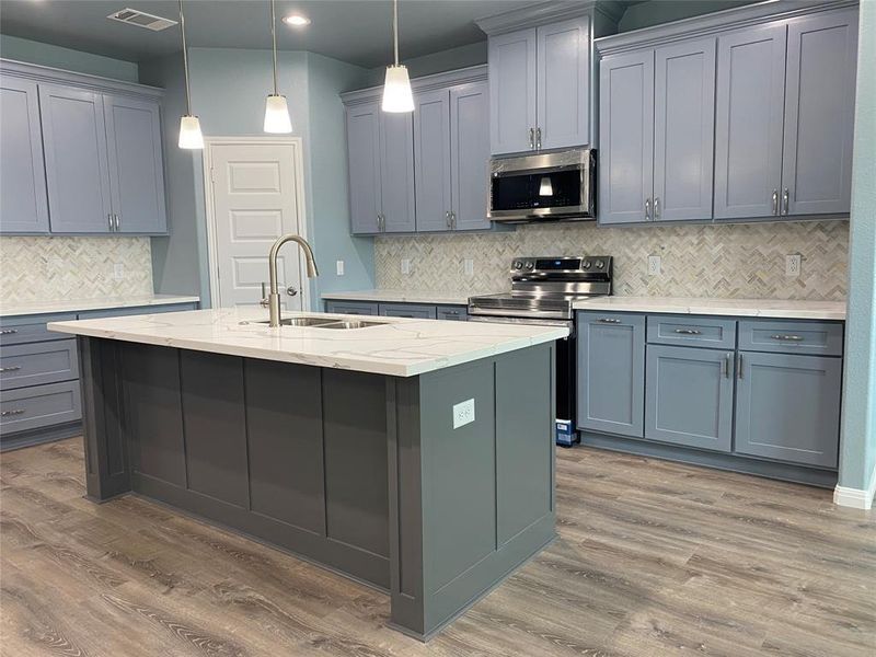 A well-appointed kitchen showcasing an inviting island and sleek stainless steel appliances. A well-appointed kitchen showcasing an inviting island and sleek stainless steel appliances.