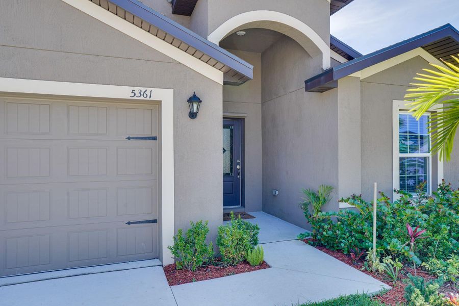 Front exterior of a new home in Celebration Pointe, Fort Pierce, FL, highlighting curb appeal (Image 20).