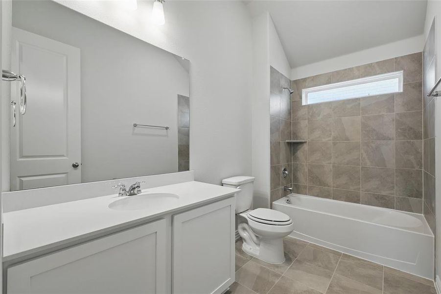Full bath with vanity, washtub / shower combination, and vaulted ceiling