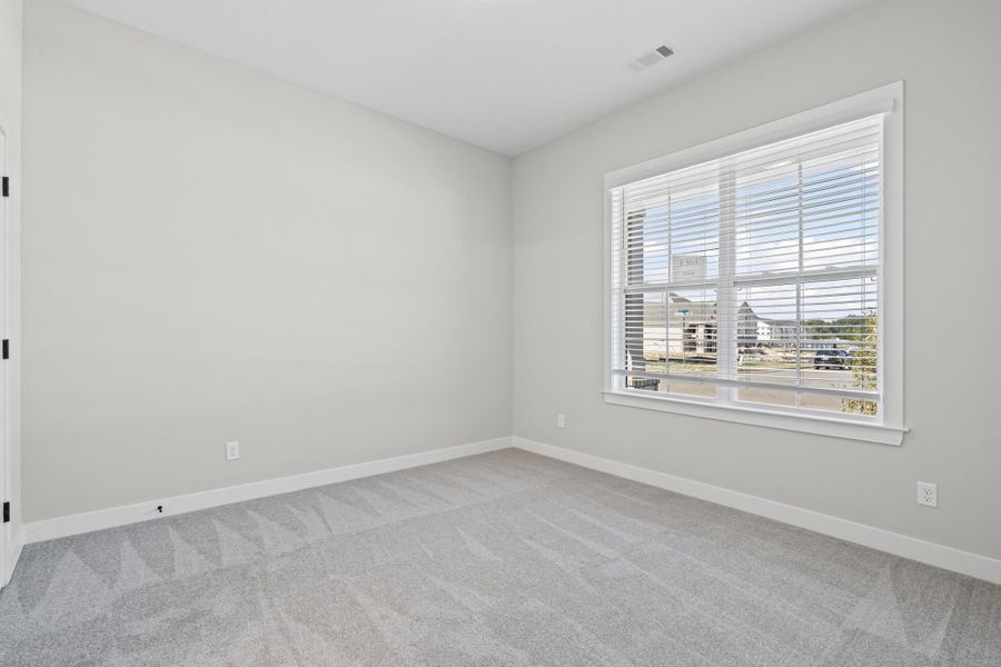 Empty room featuring baseboards and light colored carpet