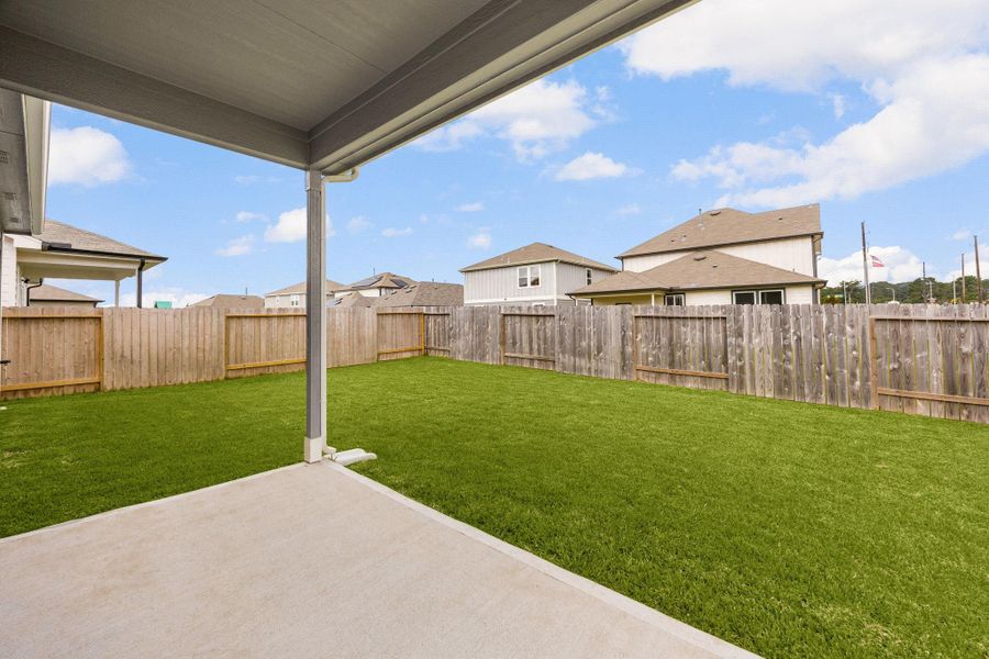 Fully fenced backyard with plenty of green space for play, pets, and entertaining.