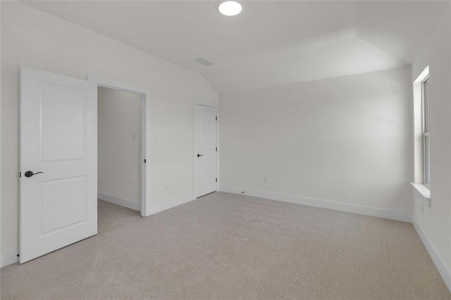Spacious room featuring neutral carpet flooring, white walls, and bright white trim