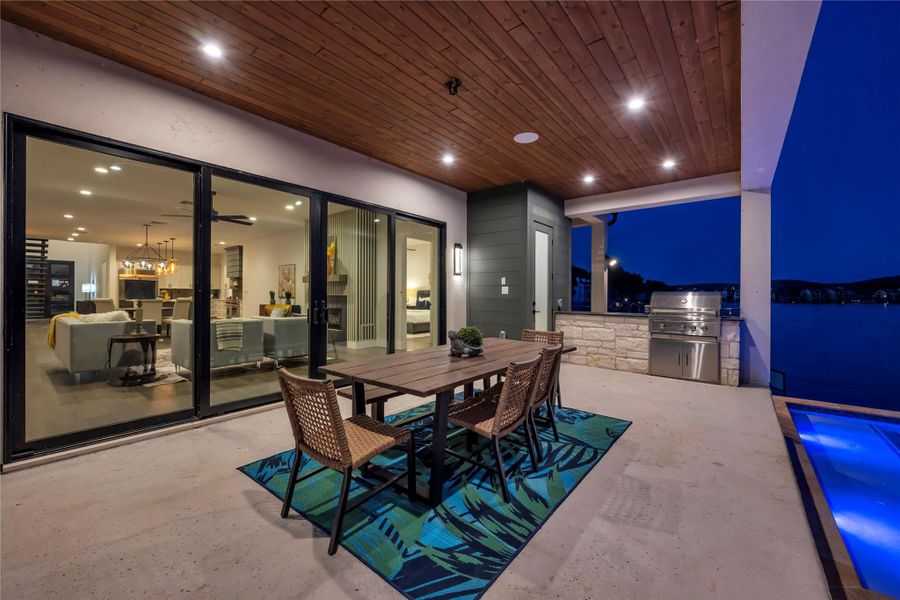 Patio at twilight with exterior kitchen, outdoor dining area, and a patio area