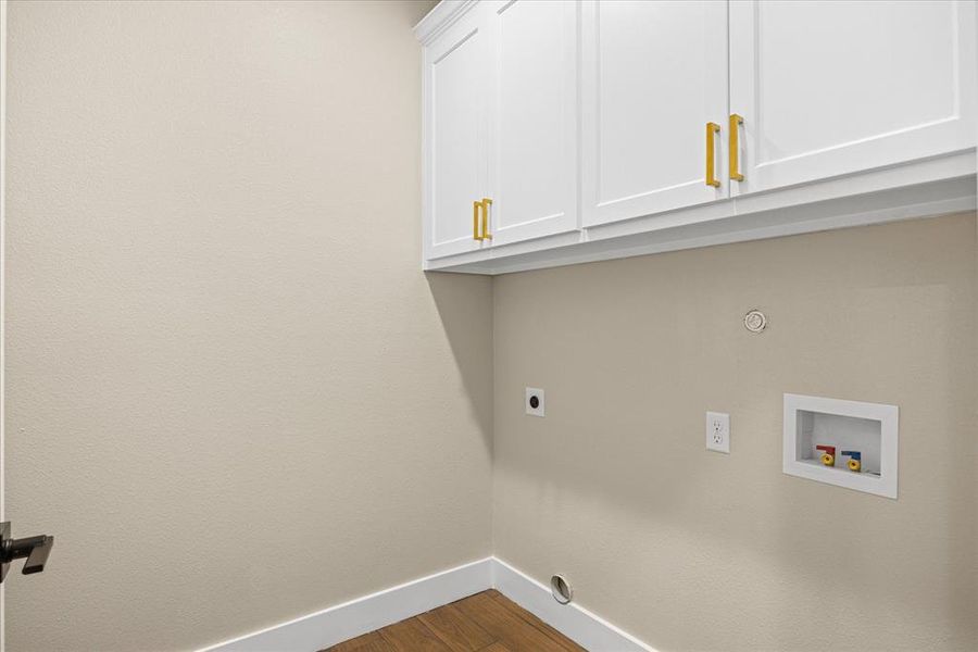Laundry area featuring dark wood-type flooring, cabinet space, hookup for a washing machine, and hookup for an electric dryer Laundry area featuring dark wood-type flooring, cabinet space, hookup for a washing machine, and hookup for an electric dryer
