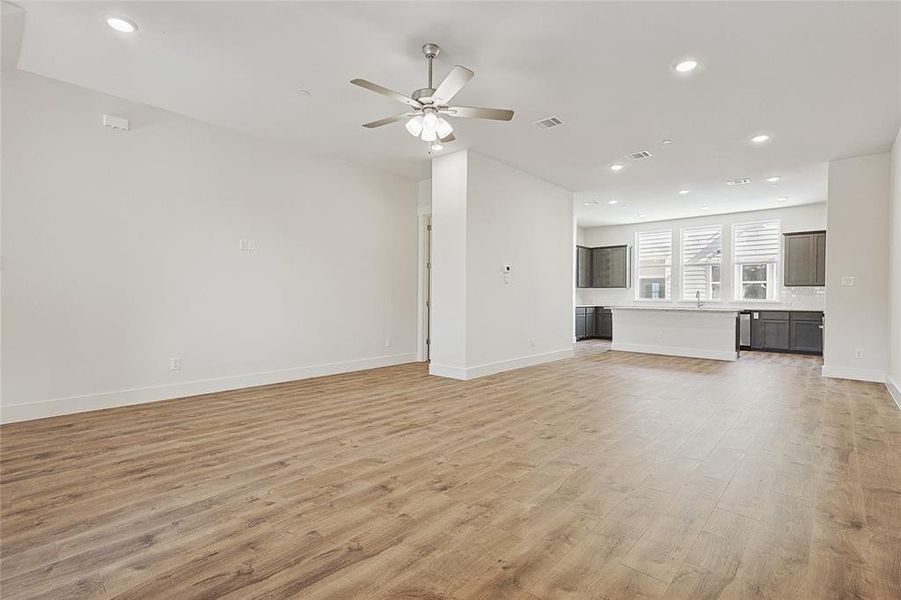 Unfurnished living room with ceiling fan and light hardwood / wood-style floors