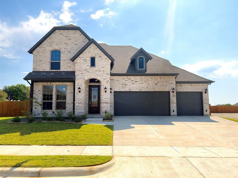 French country style house featuring a front yard and a garage