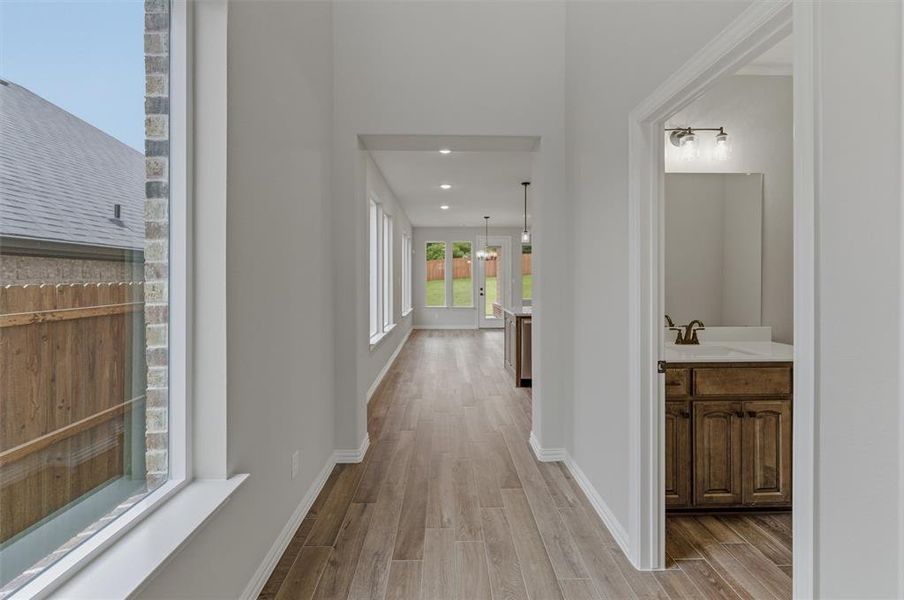 Hallway featuring wood-finish flooring, recessed lighting, and bright white walls