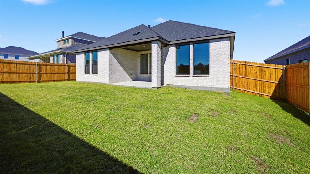 Back of property featuring brick siding, a patio, a fenced backyard, and roof with shingles Back of property featuring brick siding, a patio, a fenced backyard, and roof with shingles