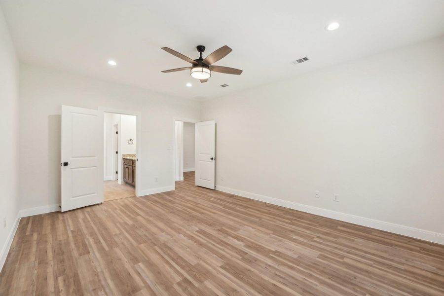 Primary bedroom featuring recessed lighting, baseboards, visible vents, and Vinyl Wood Plank floor Primary bedroom featuring recessed lighting, baseboards, visible vents, and Vinyl Wood Plank floor