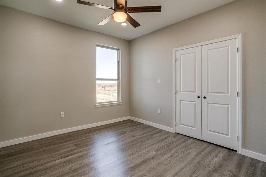 Unfurnished bedroom with wood-type flooring, a closet, and ceiling fan