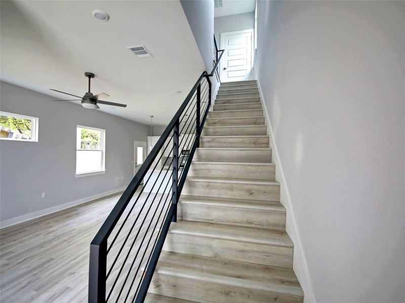Staircase featuring wood finished floors and a ceiling fan