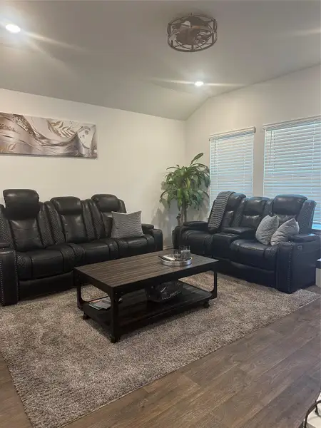 Living area with wood finished floors, lofted ceiling, and recessed lighting