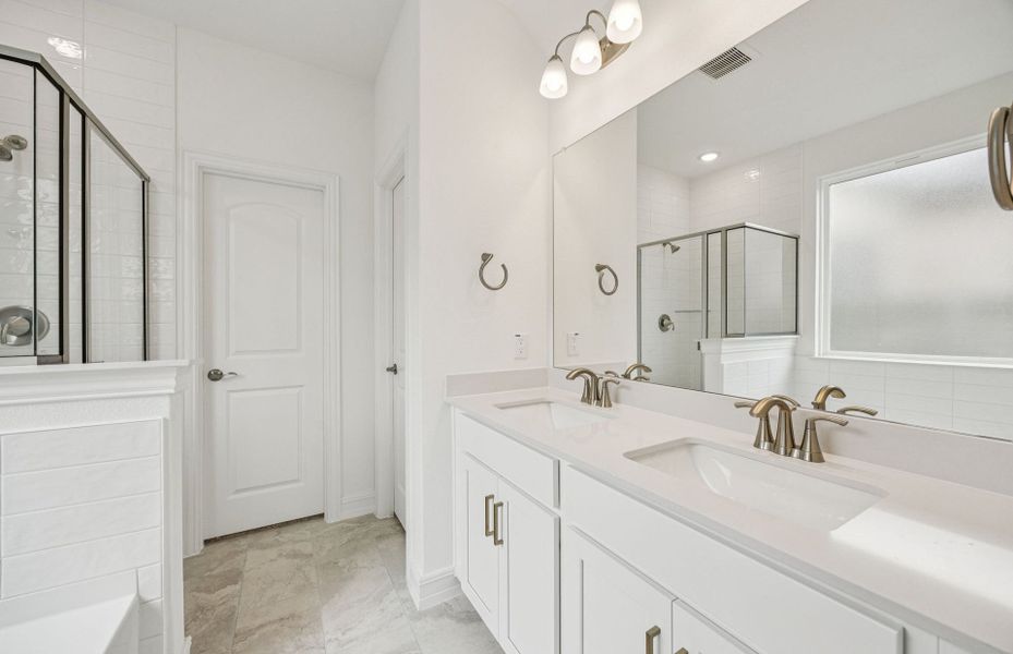 Luxurious owner's bath complete with double sinks and a generous shower  *Real home pictured