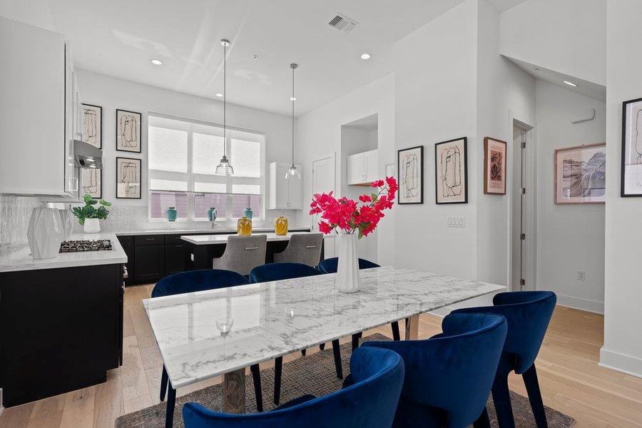 An open-concept interior features light hardwood floors, ample natural light, and a modern dining area leading into a contemporary kitchen. An open-concept interior features light hardwood floors, ample natural light, and a modern dining area leading into a contemporary kitchen.