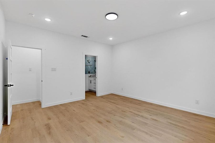 Unfurnished bedroom featuring light wood-style flooring, ensuite bathroom, and recessed lighting Unfurnished bedroom featuring light wood-style flooring, ensuite bathroom, and recessed lighting