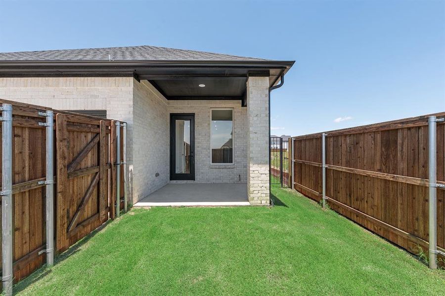 Back of house featuring brick siding, a patio, a gate, and a fenced backyard Back of house featuring brick siding, a patio, a gate, and a fenced backyard