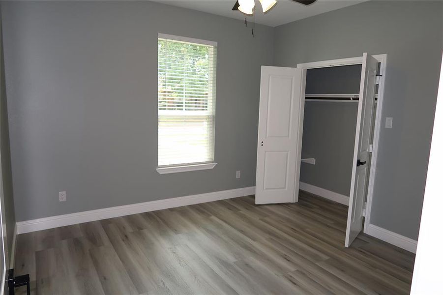 Unfurnished bedroom with light wood-type flooring, a closet, and ceiling fan