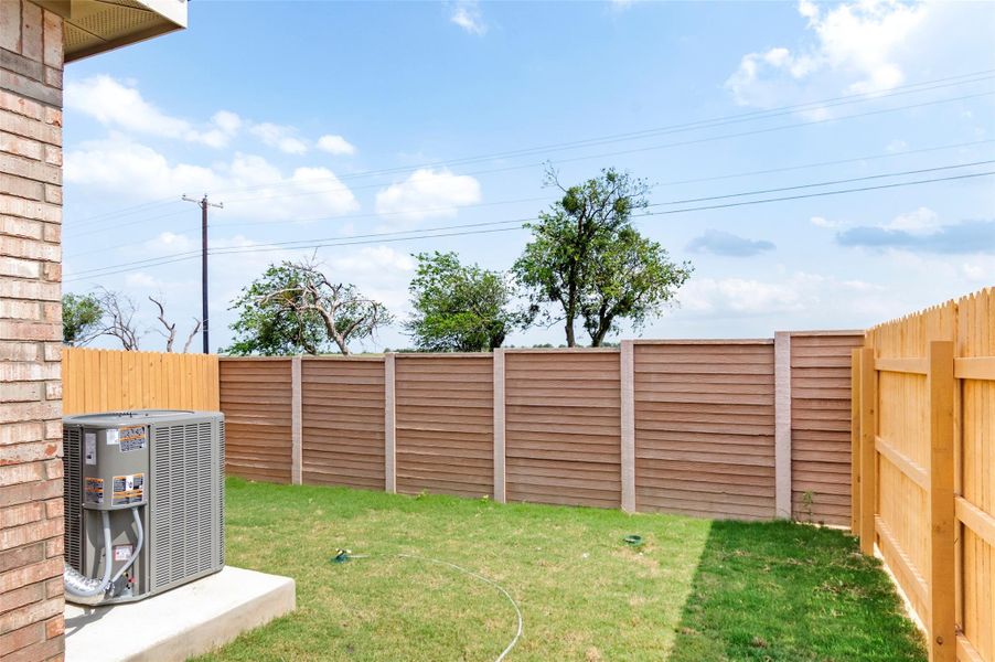 View of yard featuring central AC unit and fence