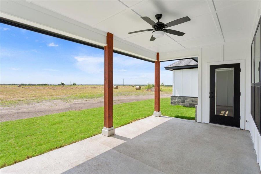 Enjoy peaceful country vistas from this welcoming covered patio, featuring a cooling ceiling fan.