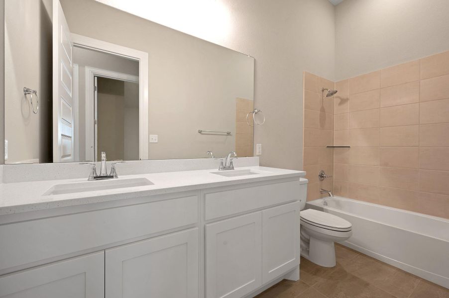 Full bathroom featuring double vanity, shower / bath combination, and tile patterned floors
